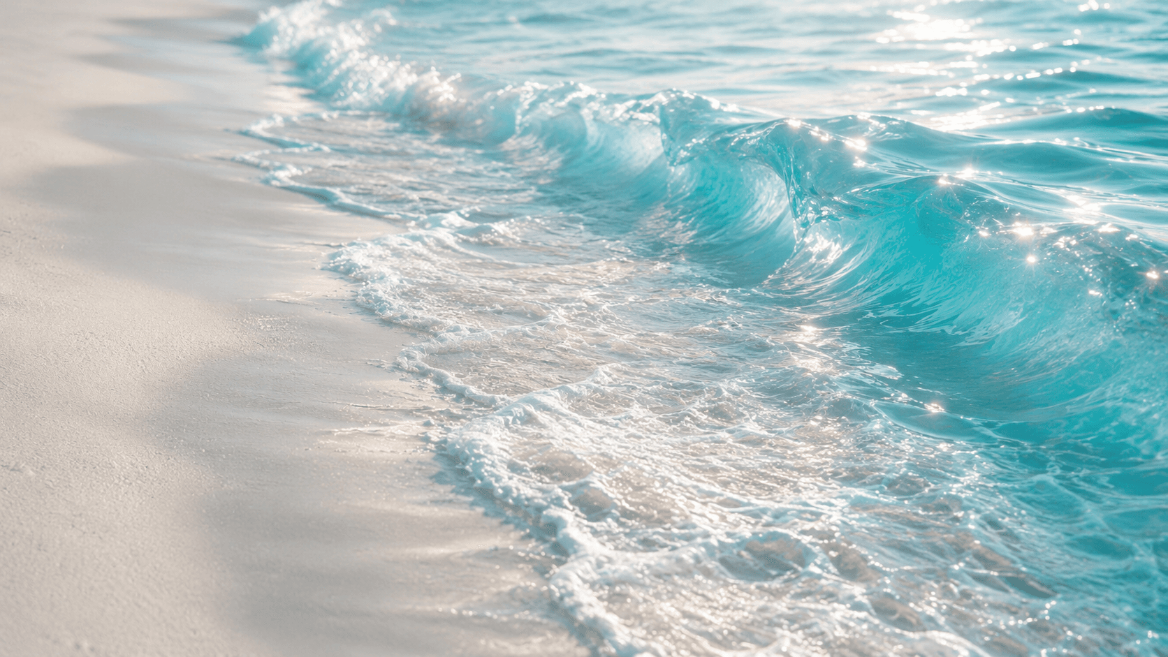 Vague sur une plage de sable clair.